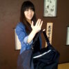 Femme souriante tenant le sac de transport d'un tatami portable léger et compact – tatamiportable.com